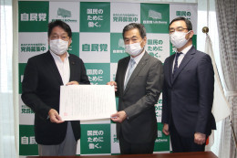 小野寺本部長?に意見書を手渡す鈴木委員長?と力久副委員長?